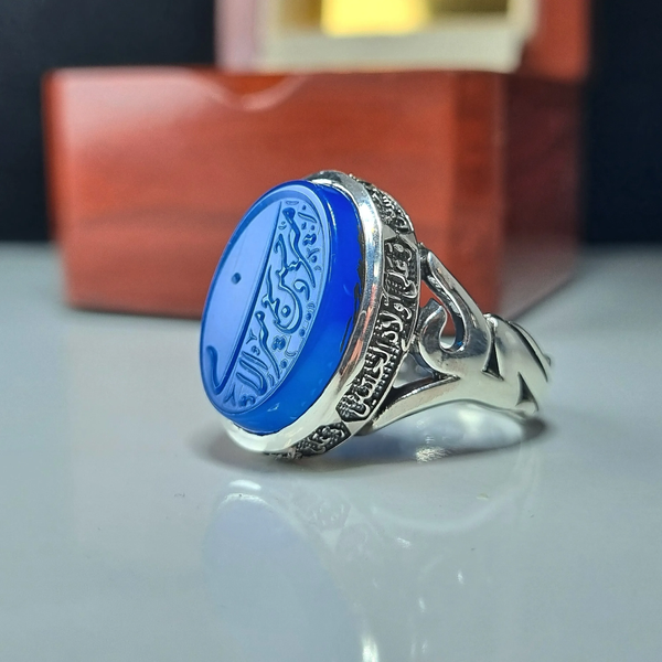 خرید انگشتر نقره مردانه عقیق آبی با حکاکی برجسته امیری حسین و نعم الامیر عیار 925 